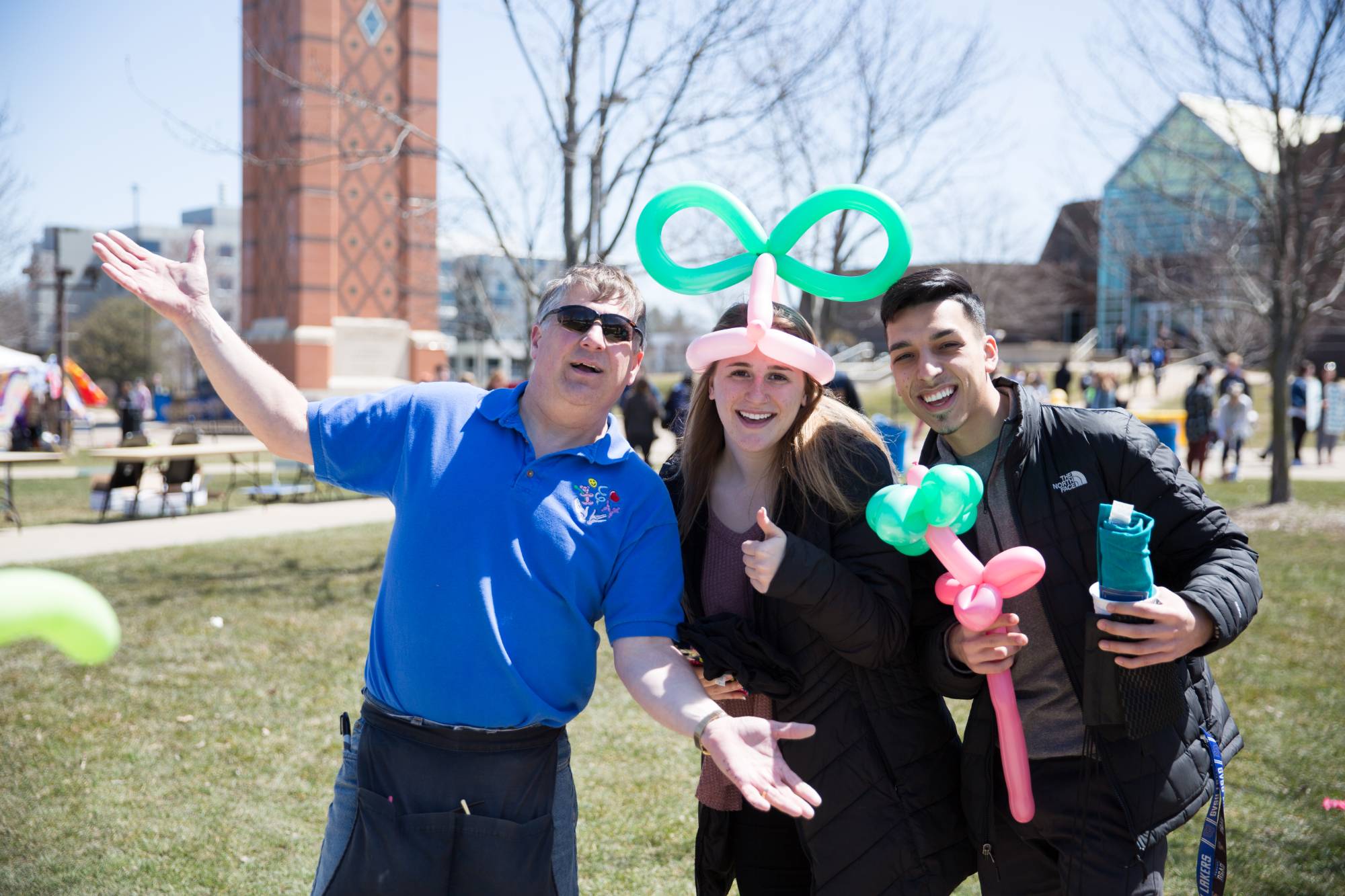 two gvsu students holding balloon art and posing with balloon artist